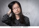 stock-photo-girl-scratching-her-head-in-confusion-grey-background-148780337